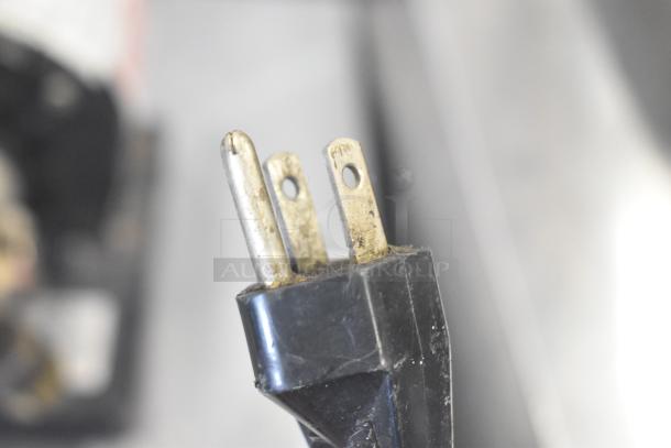 Close-up of a power plug for the Waring 32DM16 Countertop 3 Head Drink Mixer, 120 Volts, 1 Phase. Plug shows wear.