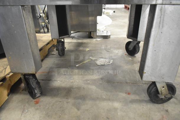 MF&B EDGE-1830-M conveyor pizza oven on casters, commercial-grade, natural gas-powered, industrial setting, visible casters.