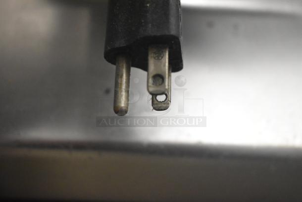 Close-up of a metal pronged electrical plug. The image lacks context about the Berkel 827A-PLUS Meat Slicer.