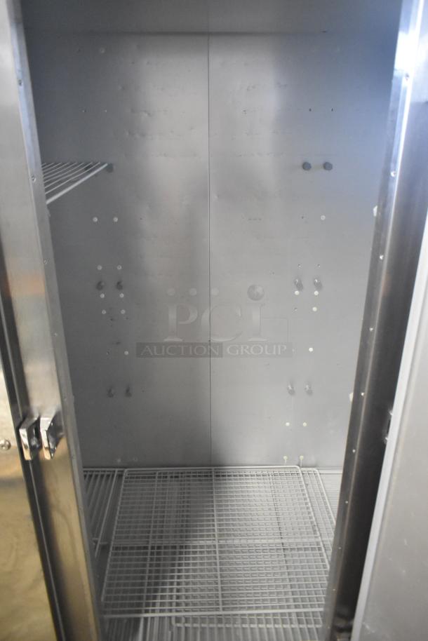 2018 Traulsen G31010 Commercial 3 Door Reach-In Freezer, open view, on casters, 115V, 1 Phase, empty interior.