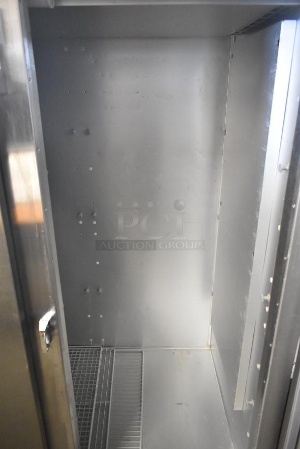 2018 Traulsen G31010 commercial 3-door reach-in freezer interior, showing shelving and stainless steel finish.