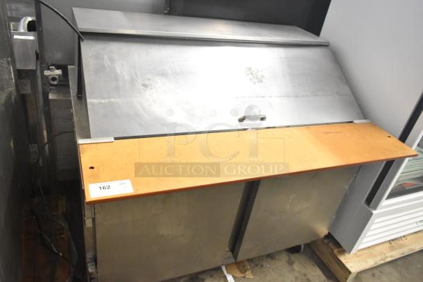 Beverage Air commercial sandwich salad prep table with stainless steel top, wood cutting board, and commercial casters. Used condition.