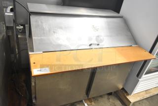 Beverage Air commercial sandwich salad prep table with stainless steel top, wood cutting board, and commercial casters. Used condition.