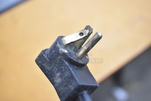 Close-up of a worn electrical plug for a Beverage Air Sandwich Salad Prep Table, showing metal prongs and black casing.