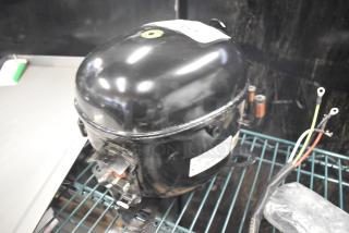 BRAND NEW Embraco NT6222UV Motor, 115V, 1 Phase, black, visible scratches, wire connections, and identification label.