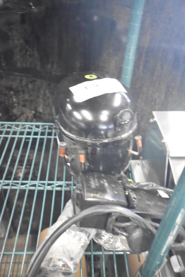 BRAND NEW SCRATCH AND DENT! Embraco NT6222UV Motor, 115 Volts, 1 Phase, labels visible, minor scratches.