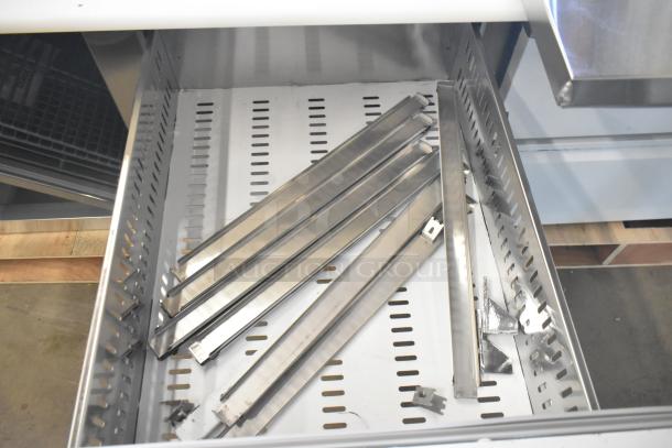 Avantco commercial pizza prep table drawer interior with metal dividers; scratch and dent condition visible.