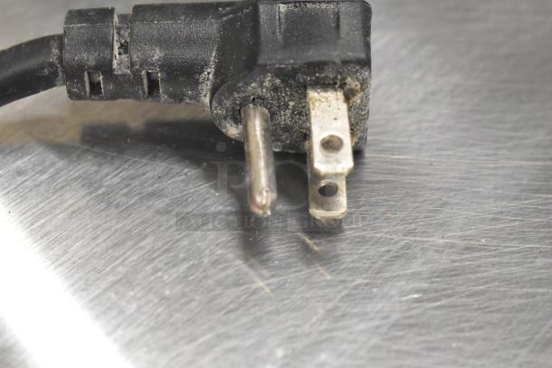 A close-up of a worn electrical plug on a Continental CPA93 pizza prep table, showing wear and dirt.