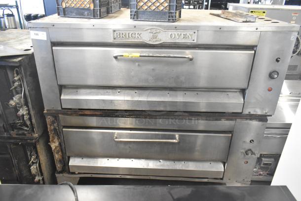 Two commercial single deck pizza ovens, stainless steel, Regina Pizzeria branding, used condition, visible wear.