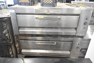 Two commercial single deck pizza ovens, stainless steel, Regina Pizzeria branding, used condition, visible wear.