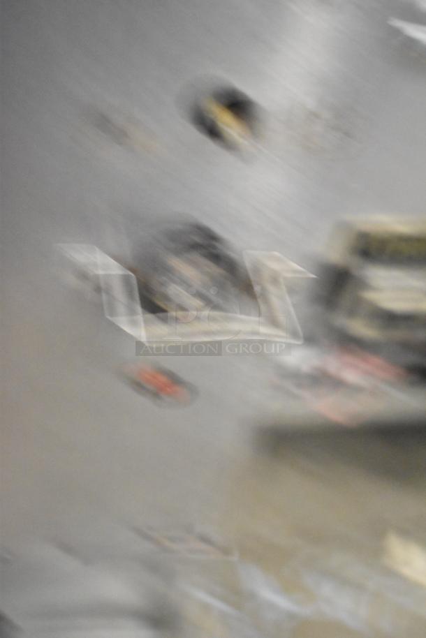 Blurry image, unable to view details of two commercial single deck pizza ovens.