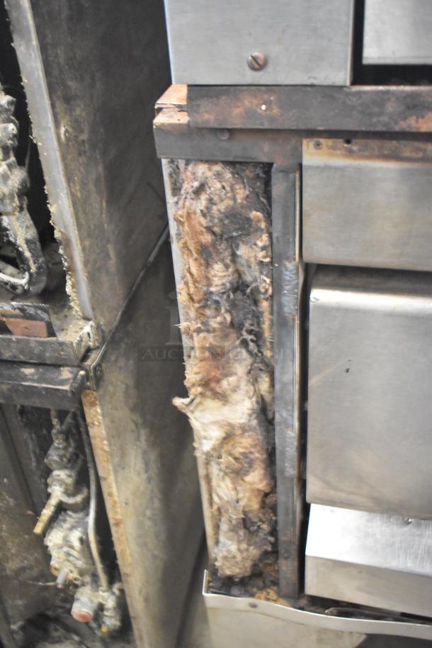 Two commercial single deck pizza ovens in well-used condition, showing wear and visible insulation.