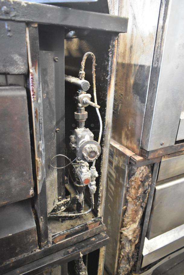 Two commercial single deck pizza ovens with visible mechanical parts. Used condition with rust and grime evident.