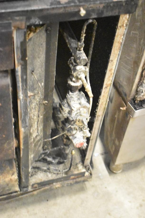 Two commercial single deck pizza ovens, visibly worn, with metal and wiring details. Conditions suggest significant use.