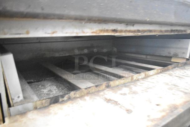 Two commercial single deck pizza ovens showing interior racks and used condition, ideal for high-volume cooking.