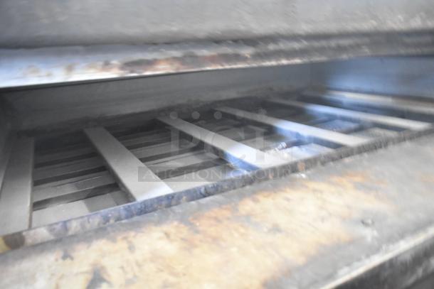 Two commercial single deck pizza ovens with metal grates, showing moderate wear. Ideal for high-volume cooking needs.