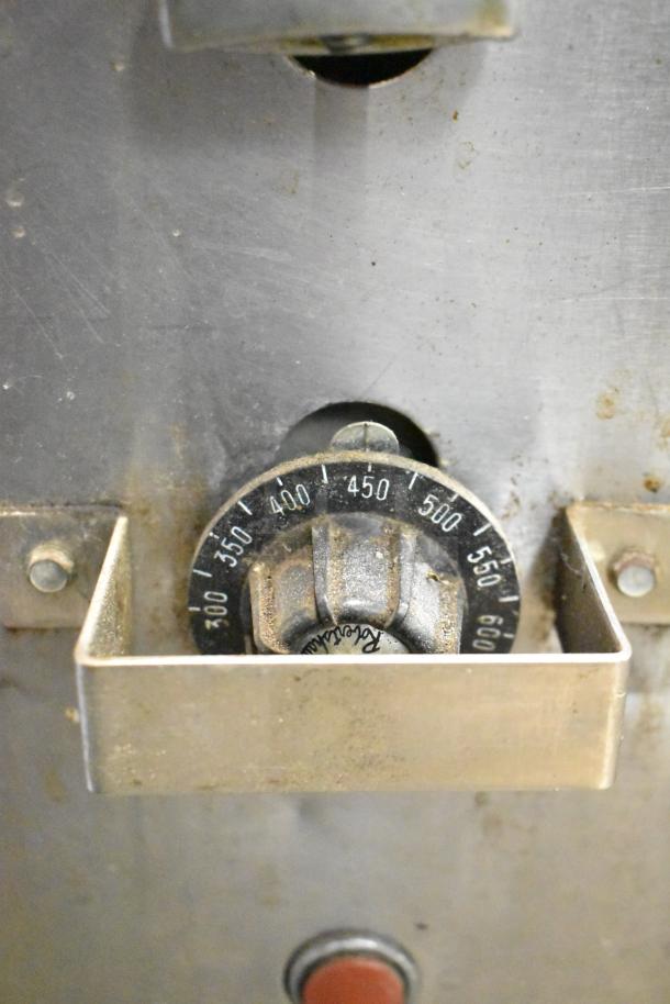 Close-up of a Montague 14-P-1 commercial pizza oven temperature dial, showing temperature settings from 300 to 600 degrees.