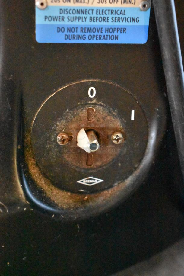 Mazzer Luigi espresso bean grinder, showing control dial with 0-1 settings. Blue label indicates safety instructions.