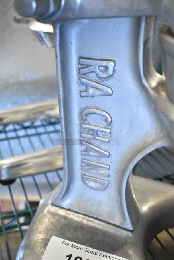 RA Chand Countertop Manual Citrus Juicer, silver metal, embossed brand name, used condition, durable construction.