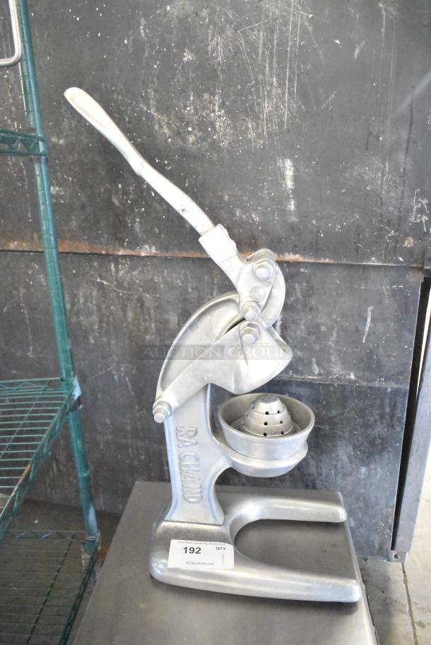 RA Chand Countertop Manual Citrus Juicer, metal finish, sturdy base, lever-operated. Visible brand marking and auction label.