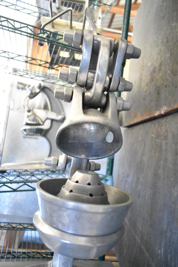 RA Chand countertop manual citrus juicer in metal, showcasing a sturdy arm and conical juice extractor base.