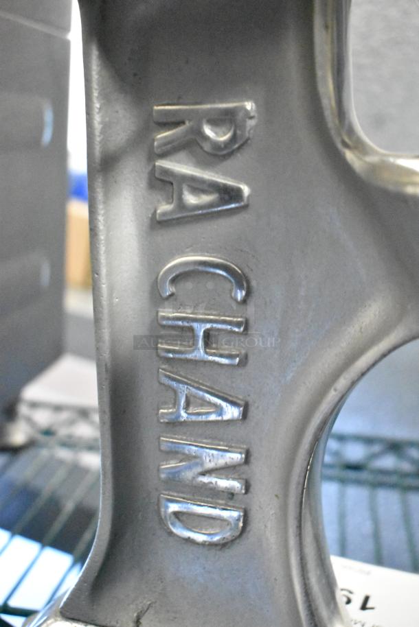 RA Chand countertop manual citrus juicer, embossed metal body, sturdy design, in good condition.