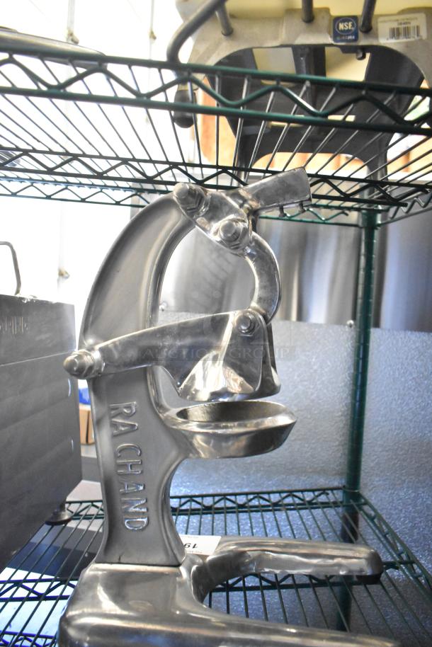 RA Chand Countertop Manual Citrus Juicer, metal finish, sturdy design, visible RA Chand branding, good condition.