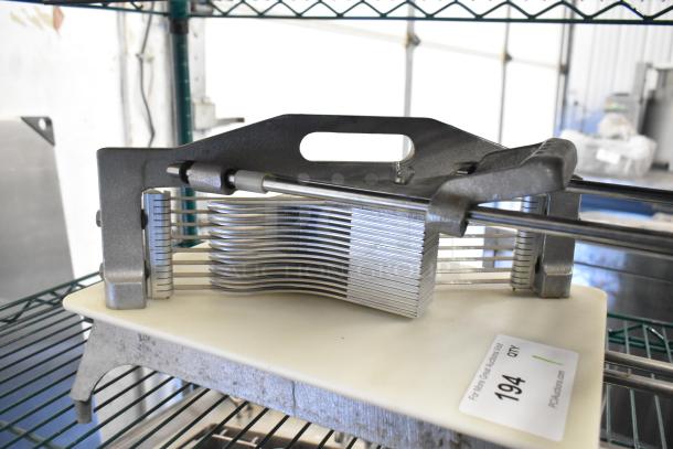 Countertop tomato slicer with metal blades and a sturdy base. Used condition, includes label for auction reference.