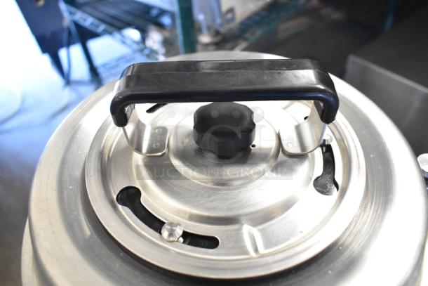 BRAND NEW SCRATCH AND DENT! Fetco TPD-30 Luxus 3 Gallon Stainless Steel Coffee Dispenser, top view showing lid and handle.