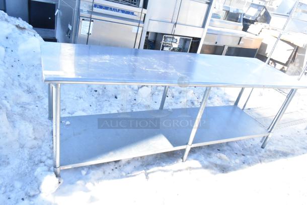 Commercial stainless steel table with under shelf, minor surface scratches, durable metal construction, suitable for kitchen use.