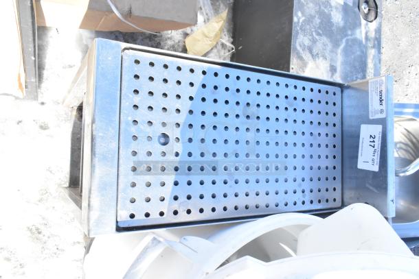 Commercial drain board with perforated surface and two under shelves, stainless steel, includes labels with item info.