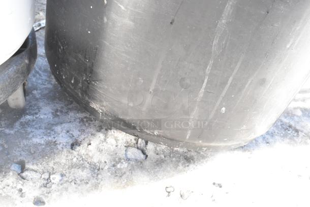 Two poly trash cans with visible scratches, showing signs of wear, containing miscellaneous contents.