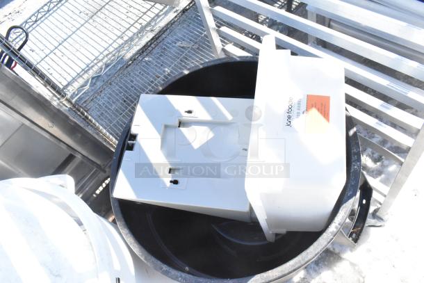 Two various poly trash cans with contents, visible branding "Jane Roode," scratch marks, and outdoor conditions.