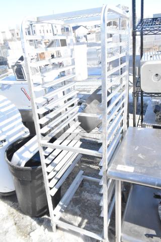 Commercial pan transport rack with multiple shelves on commercial casters, in good condition, ideal for kitchen use.