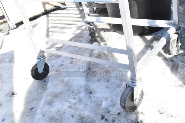 Commercial pan transport rack on durable commercial casters, metal frame, ideal for kitchen use, shown on snow.