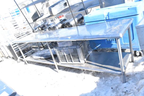Commercial stainless steel table with under shelf, durable construction, used condition, ideal for kitchen or workspace use.