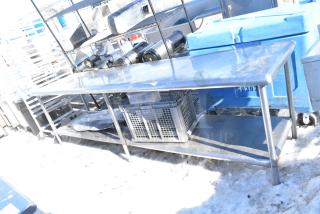 Commercial stainless steel table with under shelf, durable construction, used condition, ideal for kitchen or workspace use.