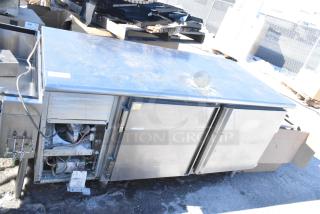 Commercial undercounter 2-door cooler with stainless steel finish. Visible wear includes minor scratches. Cooling unit access is open.