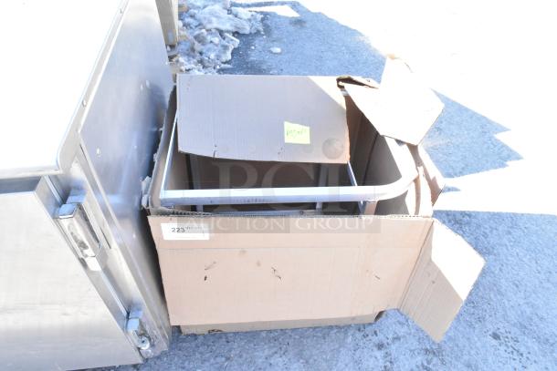 Brand new rack in cardboard box labeled "23," with visible minor scratches, ideal for storage.