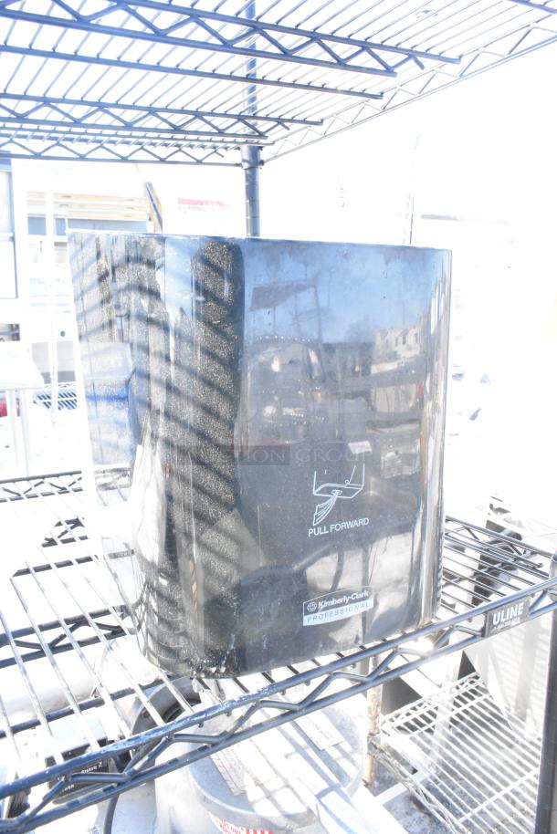 Black finish 4-tier wire shelving unit with attached Kimberly-Clark napkin dispensers. Buyer must dismantle.