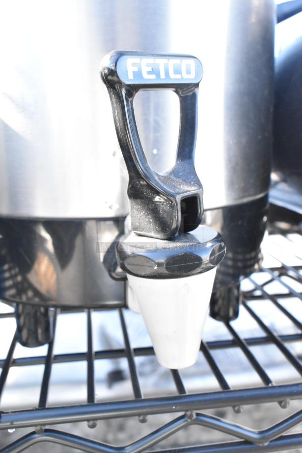 Black finish 4-tier wire shelving unit with napkin dispensers. Must dismantle for shipping. Featuring a "Fetco" handle.
