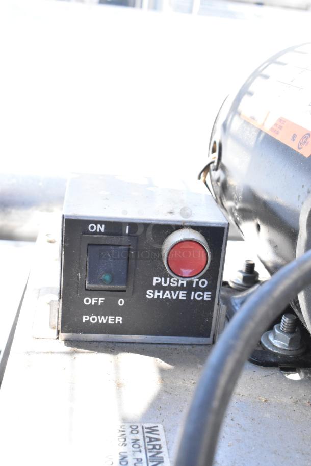 A power switch and red button labeled "Push to Shave Ice" on a metal control box.