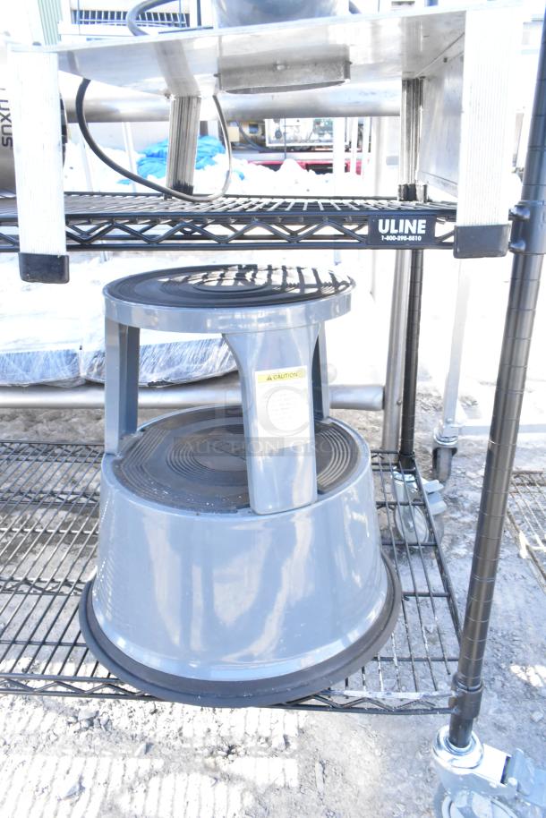 Black finish 4-tier wire shelving unit with napkin dispensers. Uline branding visible. Buyer must dismantle.