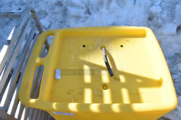 Bradley S19-921 Gravity Feed Eye Wash. Yellow body, visible hose. Outdoor setting. Used condition, no labels visible.