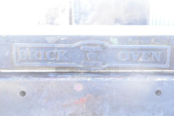 Montague 24P-2 commercial natural gas single deck pizza oven, worn "Brick Oven" label, aged metal surface.