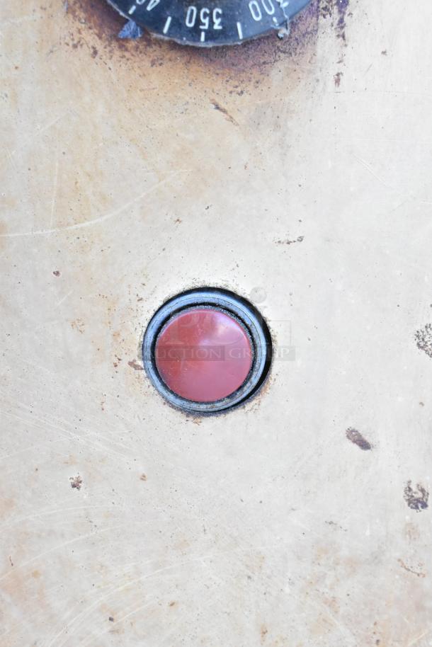 Montague 24P-2 pizza oven control panel with visible dial and button, showing signs of use.