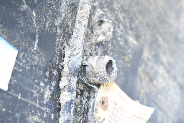 Close-up of a Montague 24P-2 pizza oven's worn connection and tag with maintenance instructions, showing signs of heavy use.