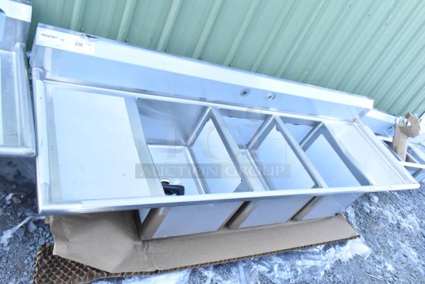 Brand new Regency 600S31824218, 16-gauge stainless steel three-compartment sink with two drainboards, no legs, minor dents.
