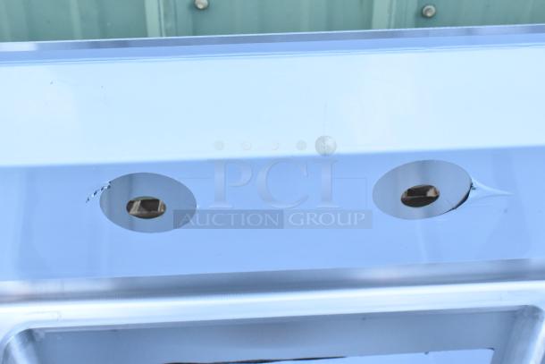 Regency 600S31824218 stainless steel commercial sink, 16-gauge, three compartments, two drainboards, scratch and dent, no legs.