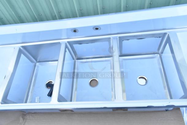 Brand new Regency 600S31824218 stainless steel three-compartment sink, no legs, 16-gauge, with two drainboards, minor scratches.